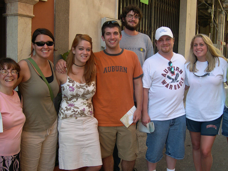 Gruppe von Sprachschülern steht lachend vor einem Gebäude in Taormina