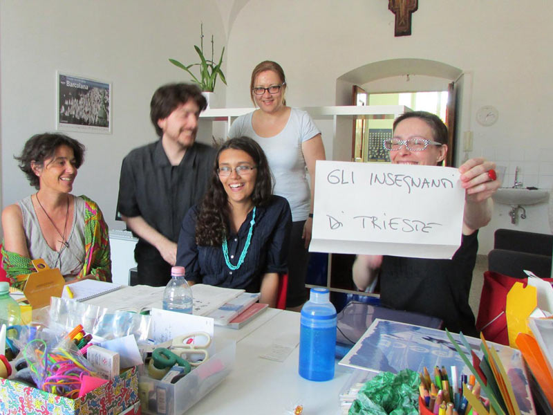 Lehrkräfte der Piccola Università Italiana Triest arbeiten gemeinsam an einem Tisch im Klassenzimmer