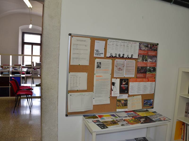 Infotafel im Eingangsbereich der Sprachschule Triest mit Aushängen und Broschüren für Sprachschüler:innen