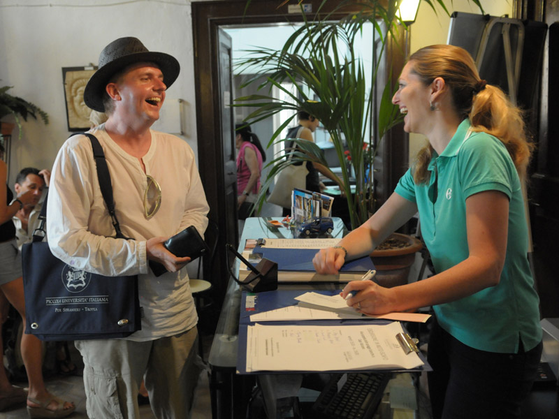 Sprachschüler im Gespräch mit einer Mitarbeiterin an der Rezeption