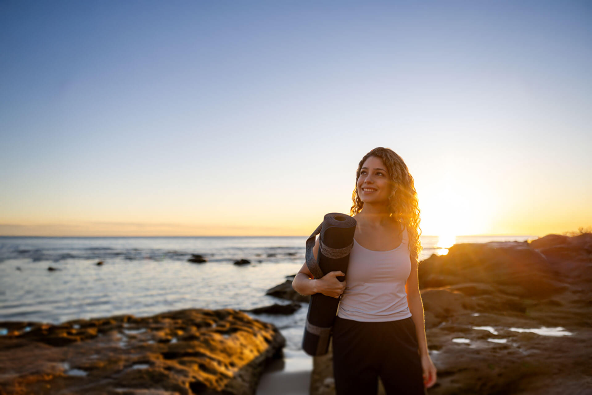 Frau genießt den Sonnenuntergang am Strand