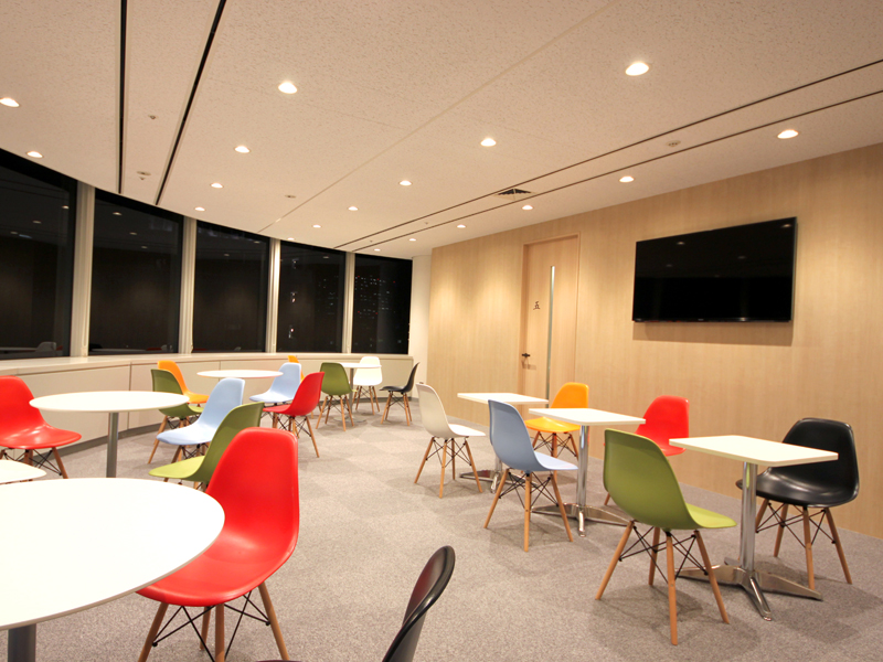 Helle Aufenthaltslounge mit bunten Stühlen in der Lexis Japan Sprachschule Kobe