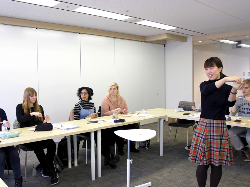 Lehrkraft erklärt Sprachinhalte während einer aktiven Unterrichtseinheit mit kleiner Gruppe