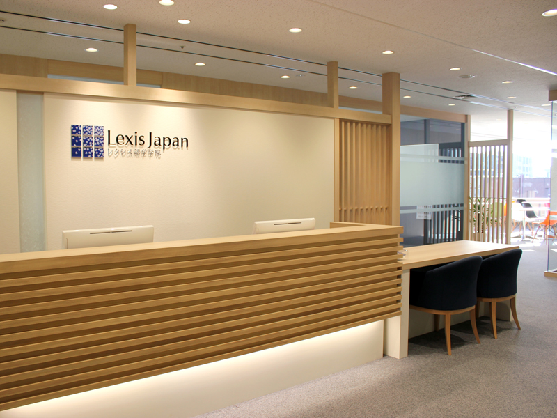 Moderne Rezeption der Lexis Japan Sprachschule mit hellem Holzdesign und Sitzbereich