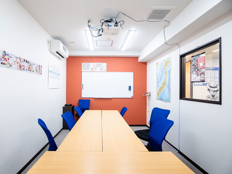 Klassenzimmer mit blauer Bestuhlung und moderner Ausstattung an der GenkiJACS Kyoto