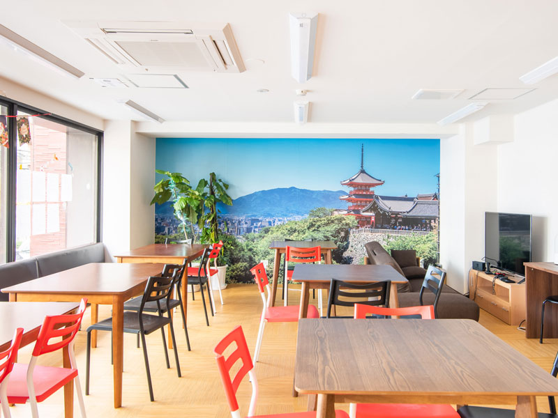 Helle Aufenthaltslounge der Genki Japanese & Culture School Kyoto mit Wandmotiv des Kiyomizu-Tempels