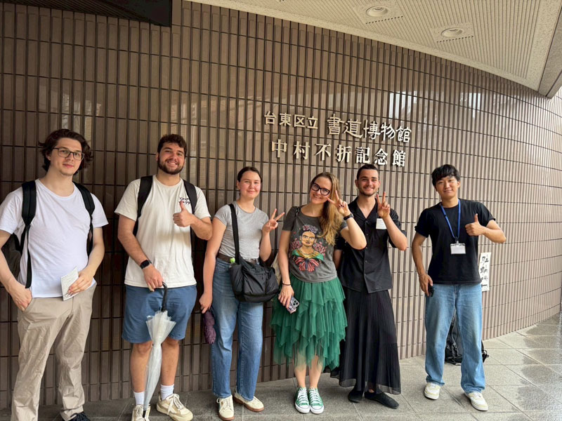 Sprachschüler der LTL Tokio stehen gemeinsam vor einem Eingang während eines Kulturausflugs