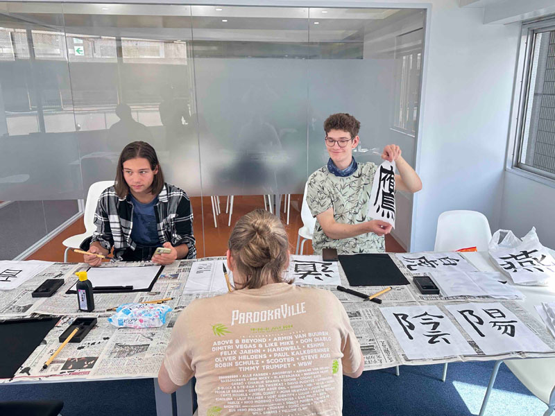 Sprachschüler der LTL Tokio nehmen an einem japanischen Kalligraphie-Workshop im Unterrichtsraum teil