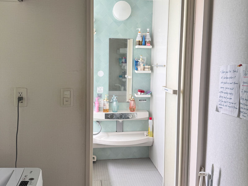 Modernes japanisches Badezimmer in einer Gastfamilie in Tokio mit Dusche, Waschbecken und Pflegeartikeln.