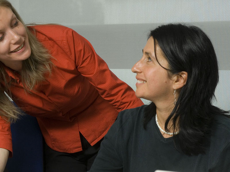 Sprachtraining in persönlicher Atmosphäre: Lehrerin unterstützt Teilnehmerin beim Englischlernen