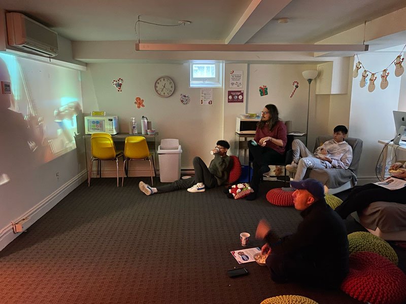 Studierende sehen sich gemeinsam eine Filmvorführung in einem gemütlichen Raum der Sprachschule an