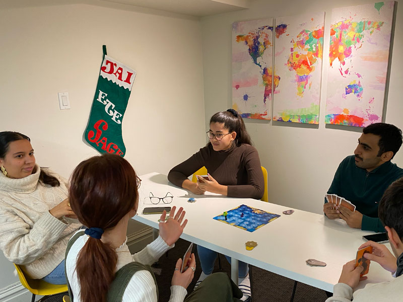 Lernende spielen gemeinsam Karten an einem Tisch im Freizeitbereich der Schule