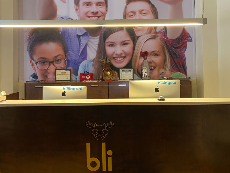 Empfangsbereich der BLI Sprachschule Montréal mit Logo und moderner Einrichtung
