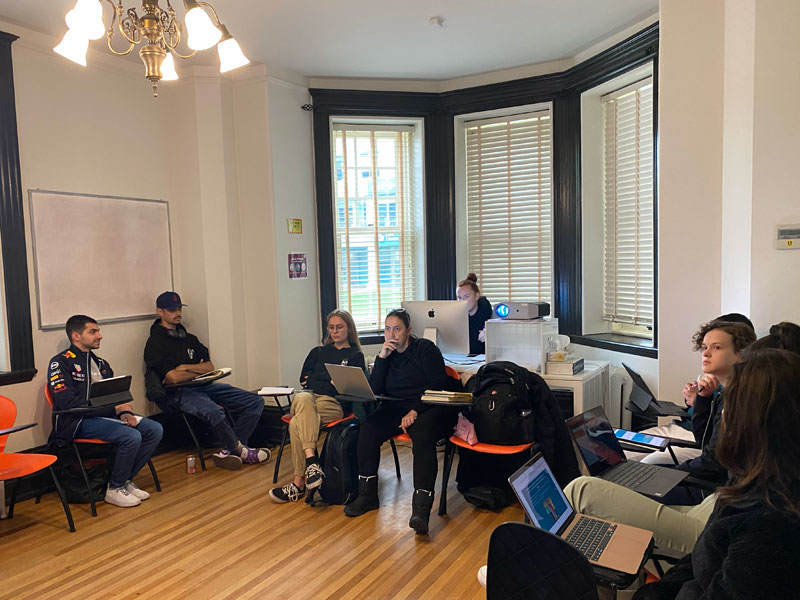 Lernende arbeiten konzentriert mit Laptops im hellen Klassenraum