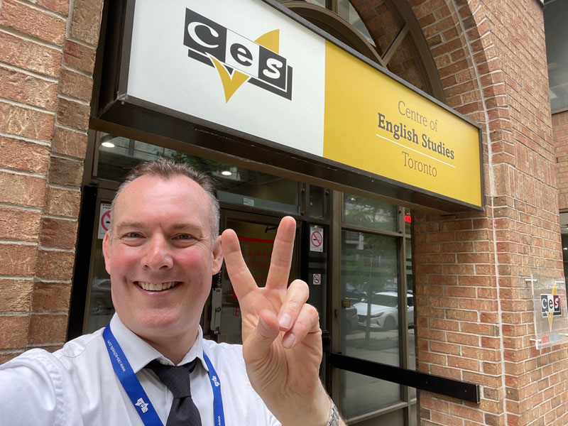 Teammitglied vor der Sprachschule in Toronto begrüßt Teilnehmende zur Sprachreise Englisch lernen