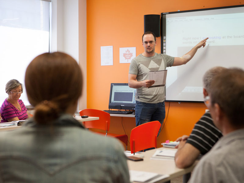 Lehrerin erklärt mit Begeisterung im Englischunterricht an der EC Toronto Sprachschule