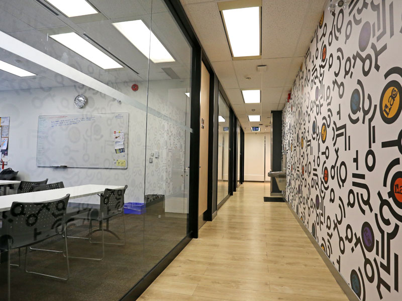Flur der ILAC Sprachschule Toronto mit Glaswänden und kreativ gestalteter Wanddekoration