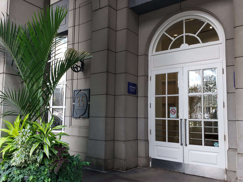 Eingang der Kaplan Sprachschule Toronto mit weissen Türen und Pflanzenarrangement