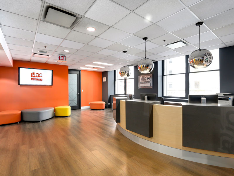 Zweiter Empfangsbereich der ILAC Sprachschule Toronto mit orangefarbenem Design und hellen Sitzmöbeln