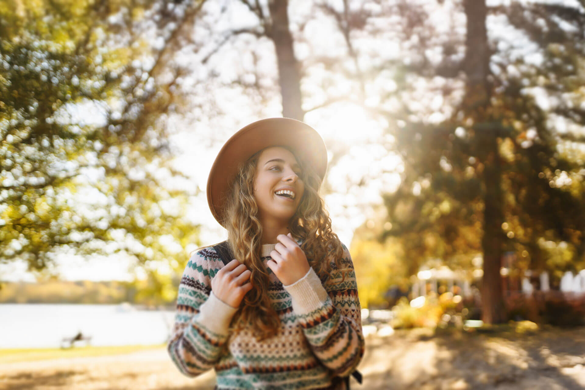 achende Person mit Hut genießt einen sonnigen Tag im Park in Riga