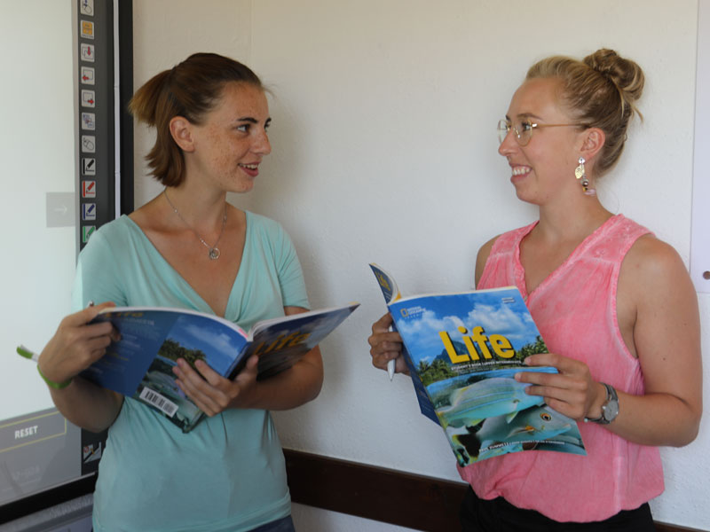 Lehrkraft präsentiert Inhalte, Hörverstehen und Wortschatztraining im Englischunterricht