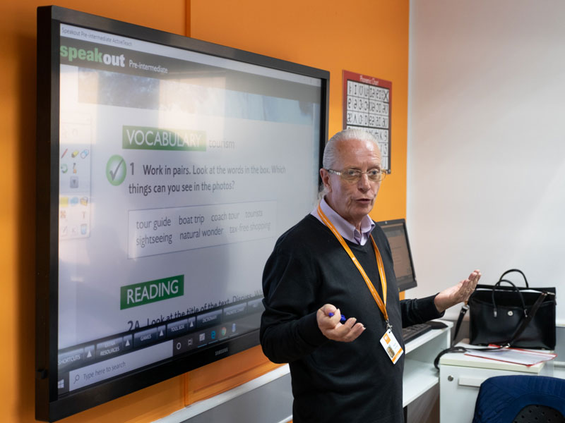 Erfahrener Lehrer erklärt neue Vokabeln im Englischunterricht Sprachkurs für Erwachsene