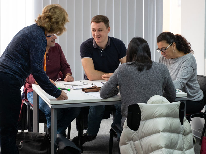Gruppe arbeitet gemeinsam an Aufgaben im Englischunterricht Vokabeln und Hörverstehen trainieren