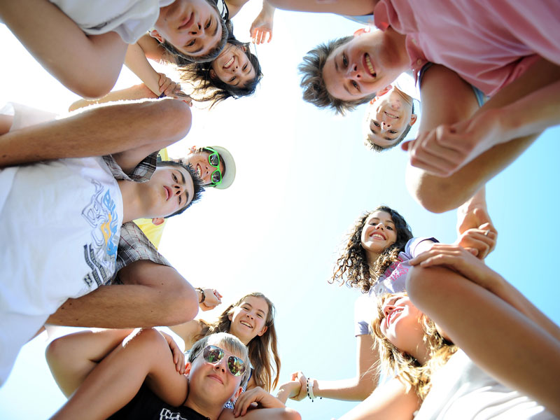 Jugendgruppe steht im Kreis und lacht während Freizeitaktivität Sprachreise Malta