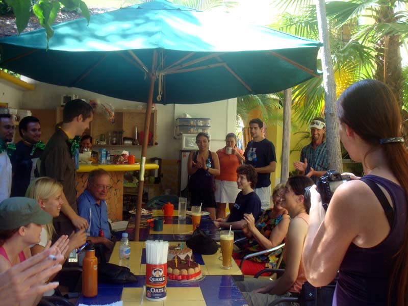 Gruppe beim Beisammensein unter Sonnenschirm, Austausch und Konversation üben im Spanischkurs