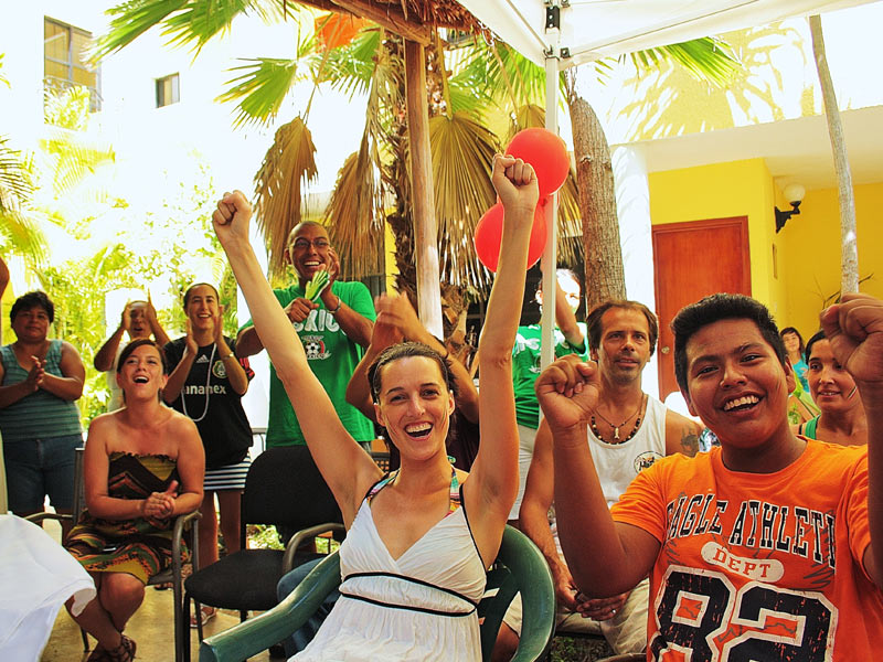 Fröhliche Gruppe feiert gemeinsam im Innenhof, Gemeinschaft erleben während der Sprachreise