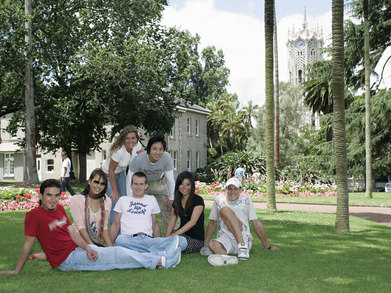 Sprachschüler im Park der Language International Auckland mit Blick auf den Uhrturm