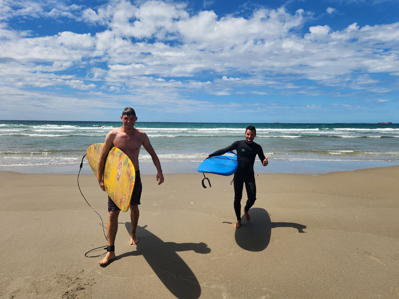 Surfer am Strand von Mount Maunganui nach dem Sprachkurs