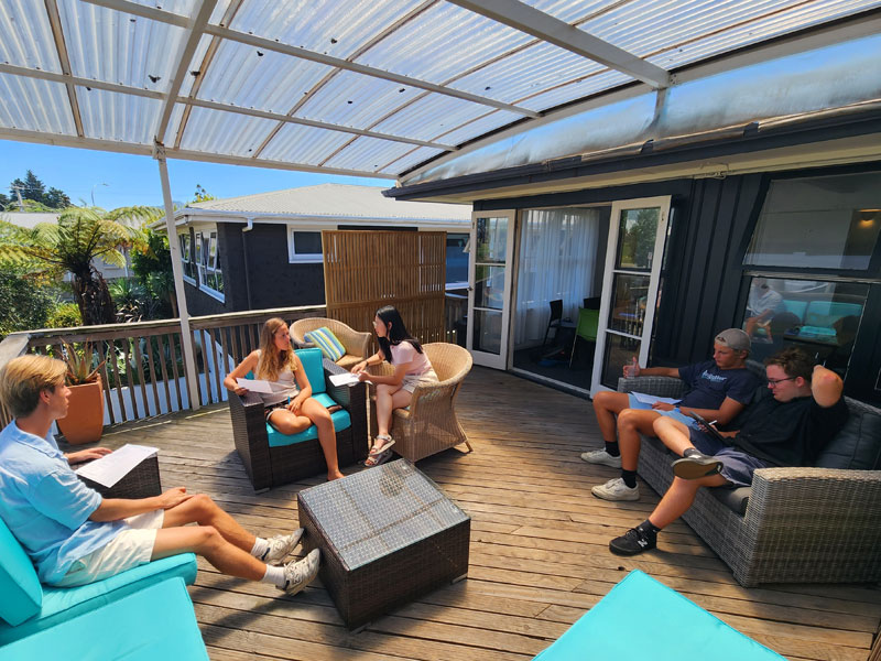 Sprachschüler beim Lernen auf der sonnigen Terrasse des Mount Maunganui Language Centre