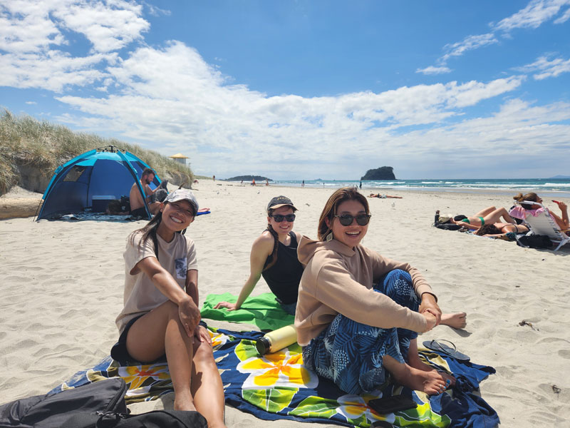 Sprachschülerinnen am Strand von Mount Maunganui in Neuseeland