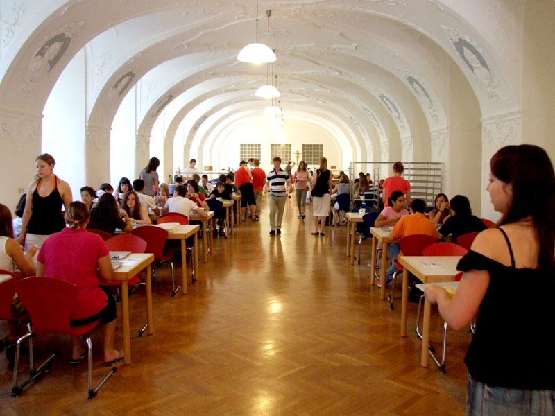 Speisesaal mit Gewölbedecke, in dem Jugendliche gemeinsam ihre Mahlzeiten einnehmen