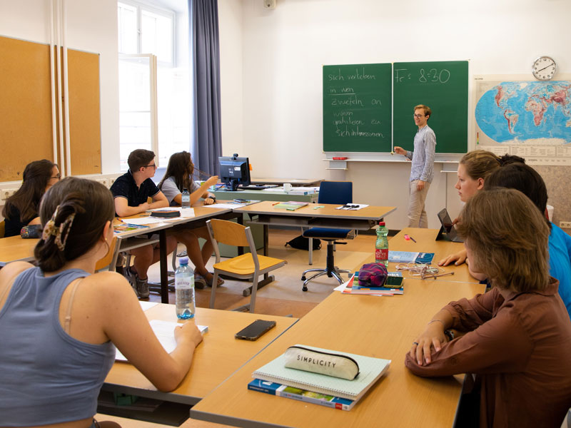 Deutschunterricht in einem hellen Klassenraum mit Lehrkraft an der Tafel