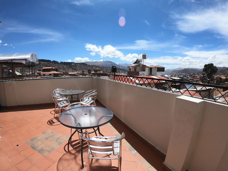 Dachterrasse mit Sitzgelegenheiten und Panoramablick über die Stadt Cusco
