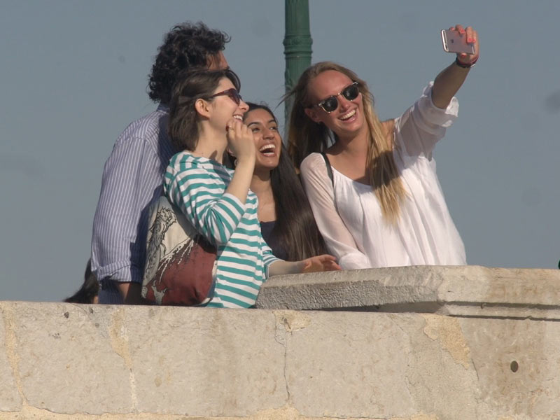 Freundeskreis macht ein Selfie bei sonnigem Wetter während des Sprachaufenthalts in Lissabon