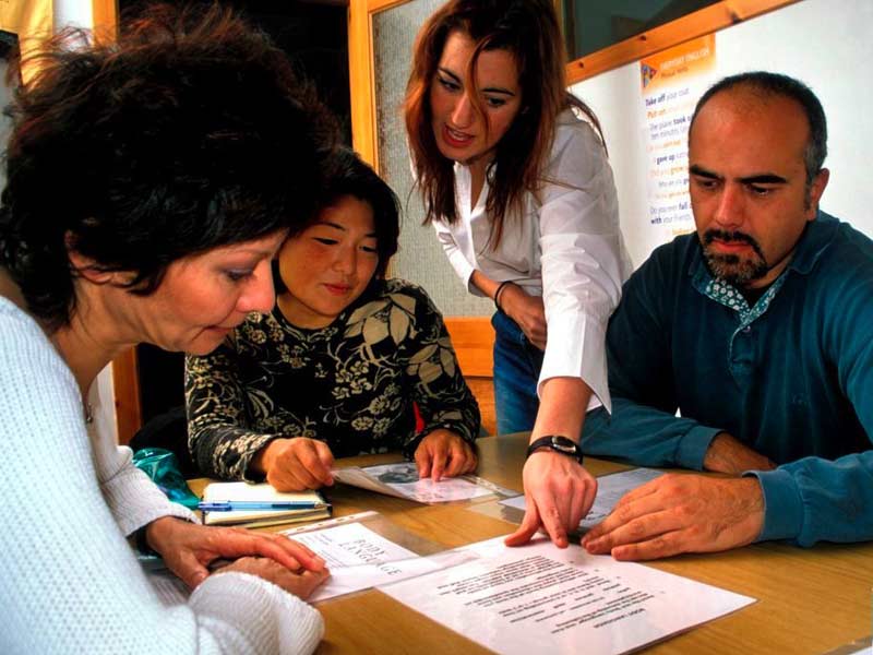 Lehrkraft unterstützt Lernende im interaktiven Englischkurs
