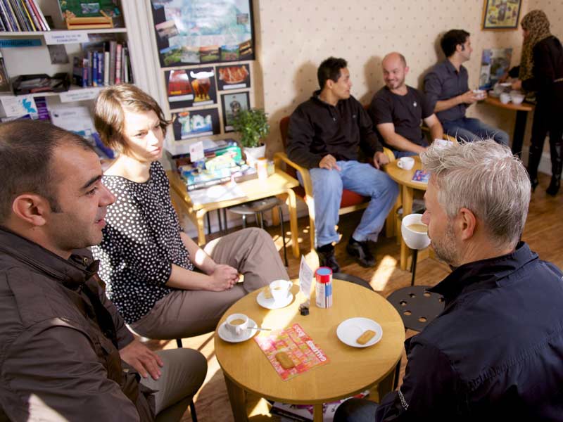 Teilnehmende im Pausenraum tauschen sich über den Englischkurs aus