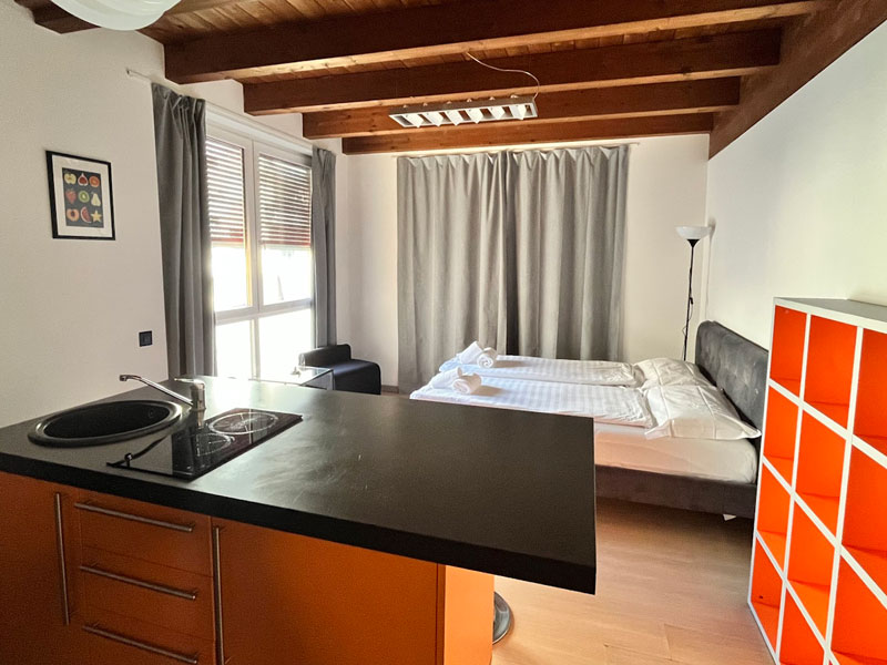 Helles Studio mit Kochbereich und Bett in Studentenunterkunft nahe Sprachschule StL WeSpeak Lugano