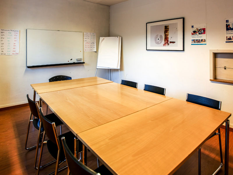 Klassenzimmer der LSI Zürich mit Tischanordnung, Whiteboard und Flipchart