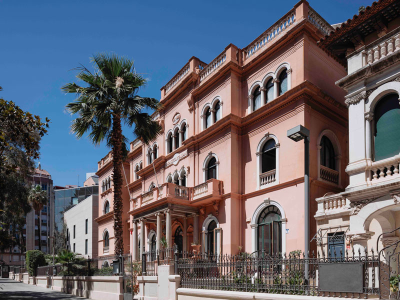 Historisches Hauptgebäude der Expanish Sprachschule in Barcelona mit Palmen und klassischer Fassade