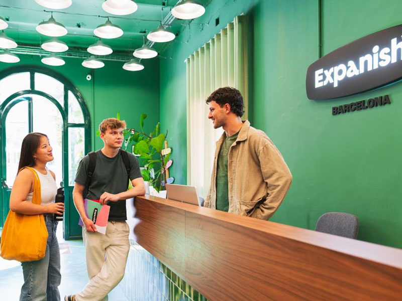 Studierende im Empfangsbereich der Expanish Sprachschule Barcelona im Gespräch mit dem Team