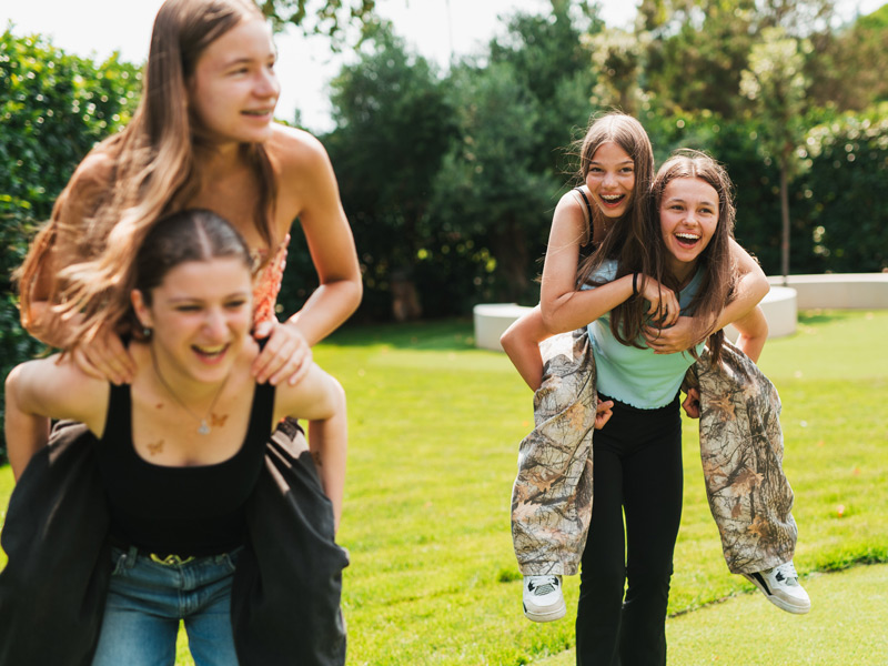 Schülerinnen spielen gemeinsam im Garten der Expanish Barcelona Sprachreise und genießen die Aktivitäten des Schülerprogramms.