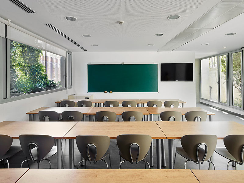 Modernes Klassenzimmer der Expanish Sprachschule Barcelona für Schüler-Sprachreisen mit großen Fenstern und ergonomischen Sitzplätzen.