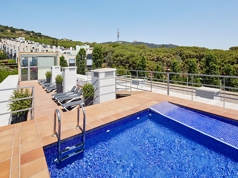 Rooftop-Pool und Sonnenterrasse der Expanish Unterkunft in Barcelona für Schüler-Sprachreisen mit Blick auf die umliegenden Hügel.