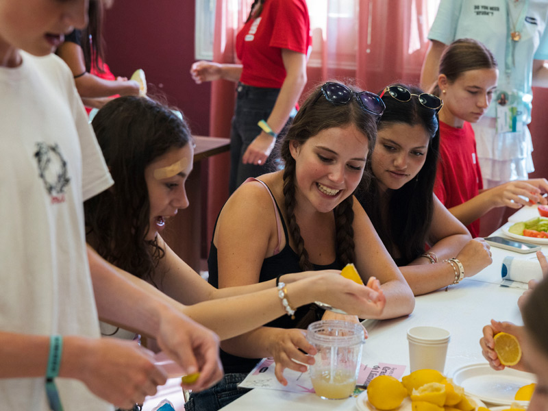 Teilnehmende der Young-Adults-Sprachreise Barcelona pressen Zitronen und genießen einen gemeinsamen Koch-Workshop im Rahmen des Freizeitprogramms.