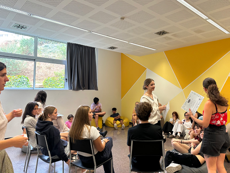 Young-Adults-Teilnehmende der Expanish Sprachschule nehmen an spielerischen Unterrichtsaktivitäten im farbenfrohen Klassenraum teil.