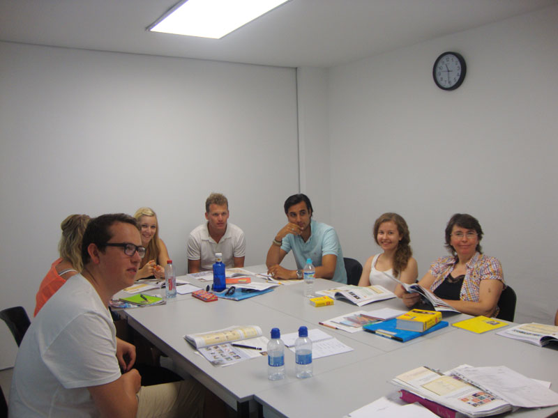 Sprachreise Ibiza: motivierte Lerngruppe arbeitet an Übungen im hellen Klassenraum